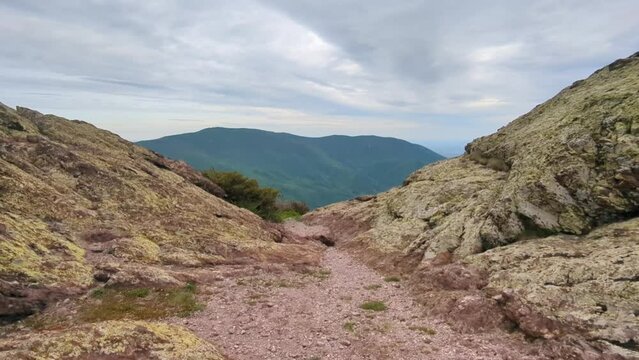 Panoramic view of the valley on top of the rocky ridge among the stones overlooking the beautiful valley. Outdoor and mountain hike background. Natural landscape in Bulgaria, Sliven