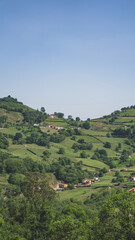 Landscape of the green countryside with houses on the hill