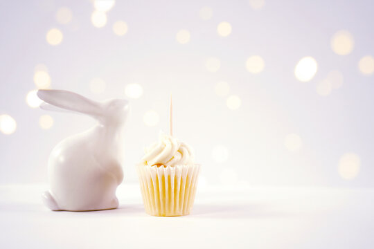 Cupcake topper product mockup. Minimal styling with bunny rabbit against a bokeh party lights background. Negative copy space.