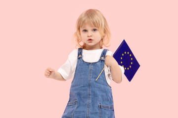 Cute child girl holding in her hand the flag of the European Union  on a pink background. The concept of supporting the union of states in war