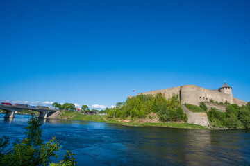 Fototapeta na wymiar Ivangorod Fortress on the banks of the Narva River on a sunny May day