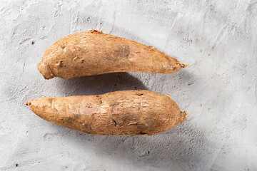 cassava root pile, on a background of gray and white texture (Manihot esculenta)
