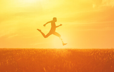 Person man running jumping in mid-air during a stunning sunset