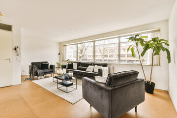 a living room with couches, chairs and a coffee table in the center of the room is large windows