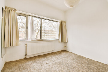 an empty room with a window and curtains on the windowsills, in front of a large white wall