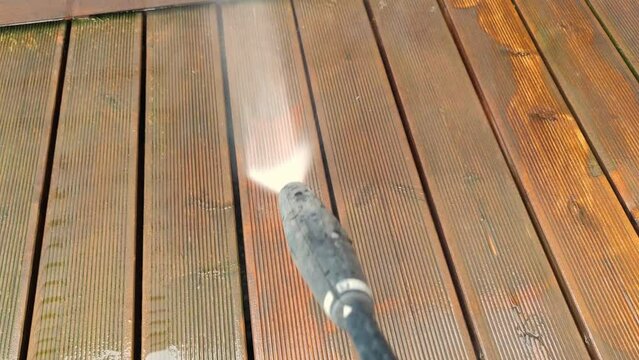 Cleaning wooden terrace decking before oiling and painting with a high pressure water cleaner
