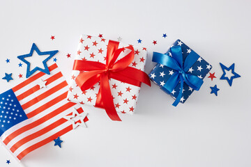 Fototapeta na wymiar 4th of July gift theme concept. Top view flat lay of gift boxes in patriotic colors, american flag, red, blue, white glittering stars on white background