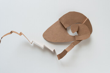 cut brown paper card with abstract form on white