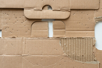 old cardboard pieces with awl holes on white - DIY crafting themed background