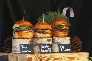 Variations of hamburgers and cheeseburgers at a snack stand at the farmers street food market in Prague