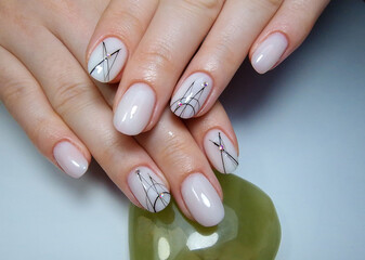 Womans nails hands with fashionable white manicure