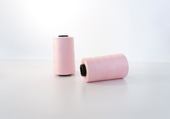 Two spools of pink thread. Accessories for sewing and needlework. Sewing production concept.