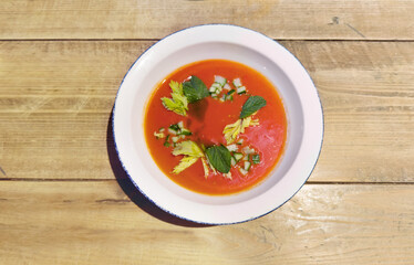 Traditional Spanish gazpacho soup in bowl on wooden table