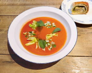 Traditional Spanish gazpacho soup in bowl on wooden table