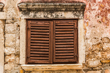 Fototapeta na wymiar View at an old wooden window of a mediterrean house