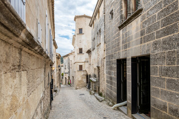 Fototapeta na wymiar A typical narrow stone street through the historic medieval village of Les Baux-de-Provence in the Alpilles Mountains of the Provence-Alpes-Cote d'Azur region of Southern France. 