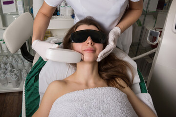 Cosmetology. Beautiful Woman Receiving Laser Hair Removal Procedure At Beauty Salon. Closeup Of Beautician Hands Doing Beauty Treatment For Female Face At Spa Salon. Facial Treatment. High Resolution