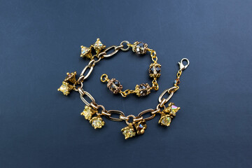 Fototapeta na wymiar Beautiful gold chain bracelet with flower bud charms, unique handmade jewelry background, rhinestone jewelry concept, promotional photo for an online jewellery store