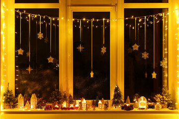 House shaped lanterns and Christmas decor on windowsill indoors © New Africa