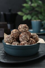 Bowl of delicious sweet chocolate candies on black table
