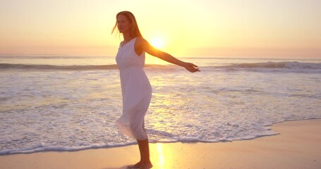 Travel, beach and woman with freedom, sunset and cheerful with happiness, summer vacation and getaway. Female person, tourist or girl on a seaside holiday, sunlight and carefree on a break and moving