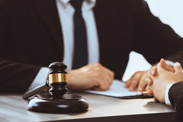 Lawyer colleagues or legal team working or drafting legal document at law firm office desk. Gavel...