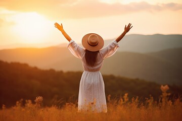 Backlit from behind calm happy free woman with open arms enjoying  a beautiful moment life on the seashore at sunset