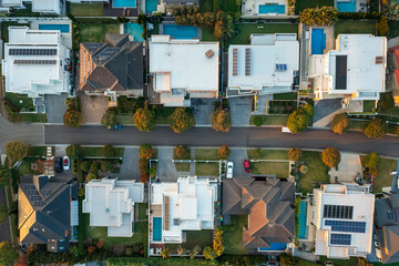Top down aerial view of modern upmarket houses with pools and rooftop solar in outer suburban Sydney, Australia.