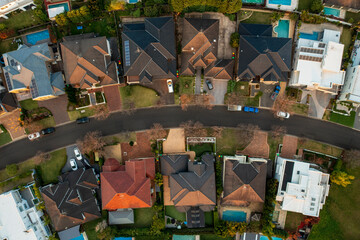 Aerial top top down view of upmarket houses on a curved street in the fading winter light in...