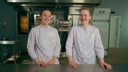 a team of smiling professional bakers in a professional kitchen in a bakery before the start of baking production