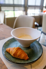 Truffle soup and croissant and blur windows view in background