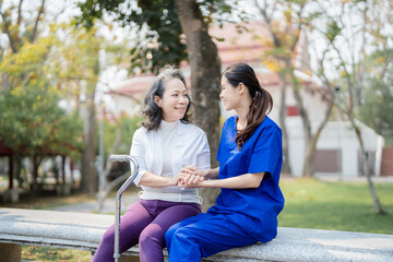 Patient care, female care, young Asian women are taking care of the elderly, providing crutches and walking for patients, and exercising their legs and knees in the park parks.