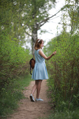 Fototapeta premium Girl in blue dress in green park