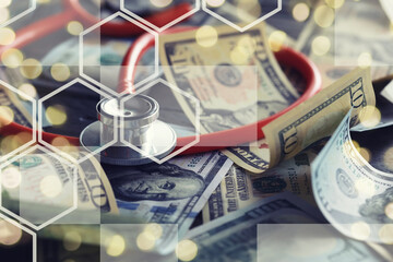 Close up red stethoscope on the US dollar banknote on wooden table. Health check or money and...