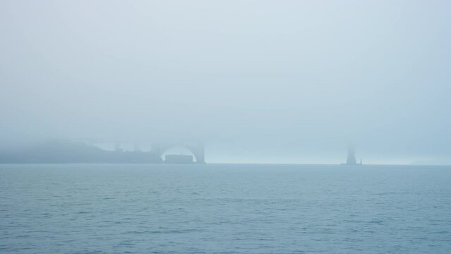 A hint of the Golden Gate Bridge is visible under a thick cover of morning fog