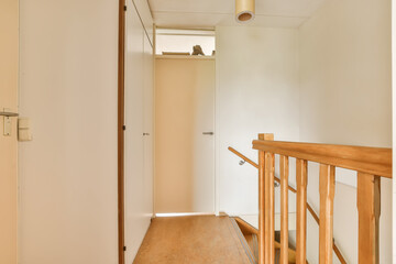 an empty room with wooden stairs and a light fixture on the wall above it is a door that leads to another room