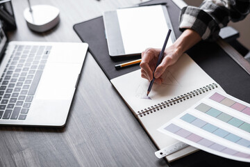Graphic designer working with sketching logo design at office.