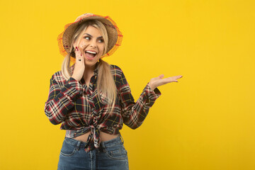 Beautiful brazilian woman, with festa junina clothes, on yellow background
