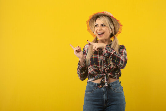Beautiful brazilian woman, with festa junina clothes, on yellow background