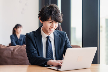 Obraz premium オフィスで笑顔で働くビジネスマン