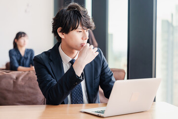 Fototapeta premium オフィスで笑顔で働くビジネスマン