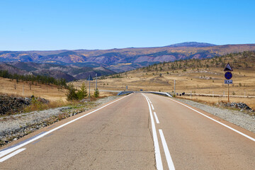 A picturesque empty paved road on a sunny autumn day.