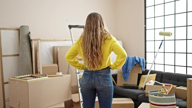 Young blonde woman standing backwards at new home