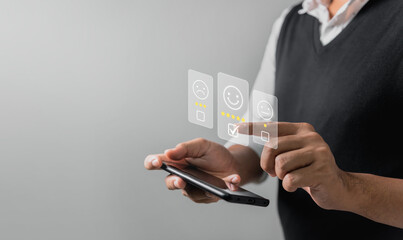 Businessman pressing face emoticon rating on virtual touch screen to service experience. Customer service and Satisfaction concept.