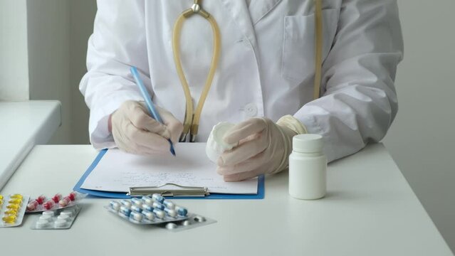 Female doctor holding pills bottle and writing prescription in clinic. Healthcare, medical and pharmacy industry concept