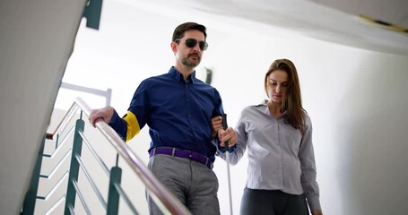 Young Woman Helping Blind Man With White Stick