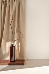 Aesthetic home interior decoration, brown vase with branches on table, empty white wall, beige linen curtain with sunlight shadows, lifestyle neutral elegant still life