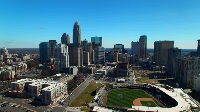 Aerial Shot Of Cars On Streets By Truist Field And Buildings, Drone Flying Forward Over City Against Sky On Sunny Day - Charlotte, North Carolina
