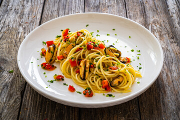 Spaghetti with mussels on wooden table
