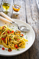 Spaghetti with mussels on wooden table
